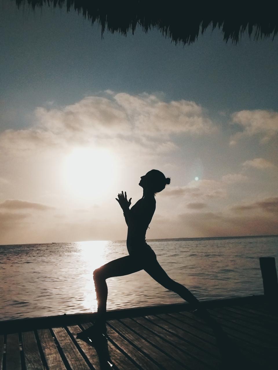 Postura al amanecer frente al mar